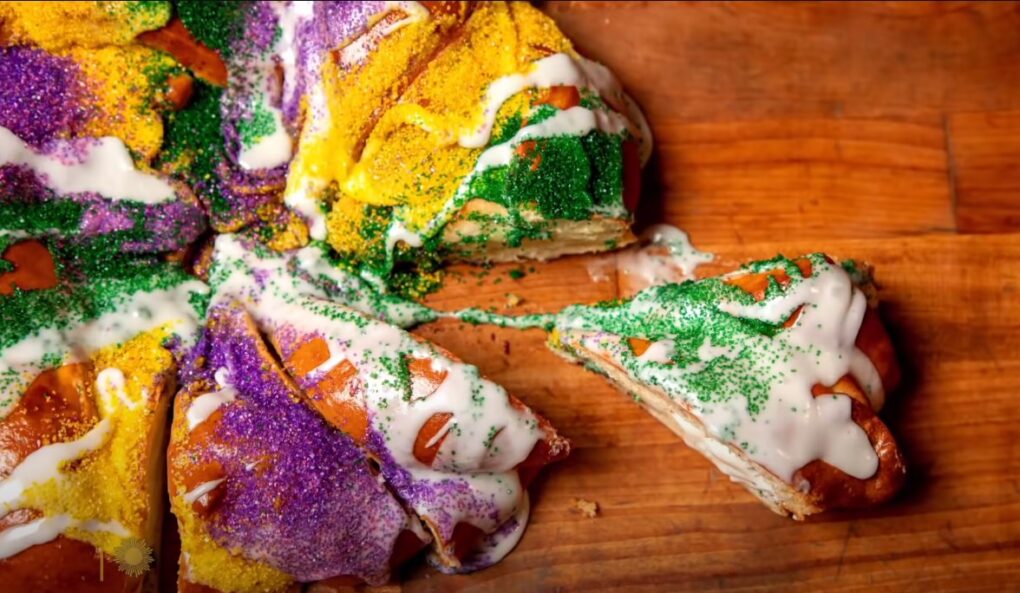 a slice of a king cake cut from the main circle of the cake with white cream