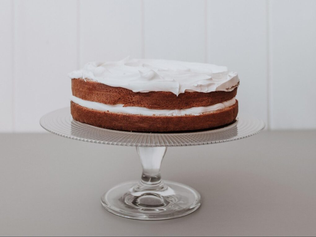 A cake with cream on a glass tray