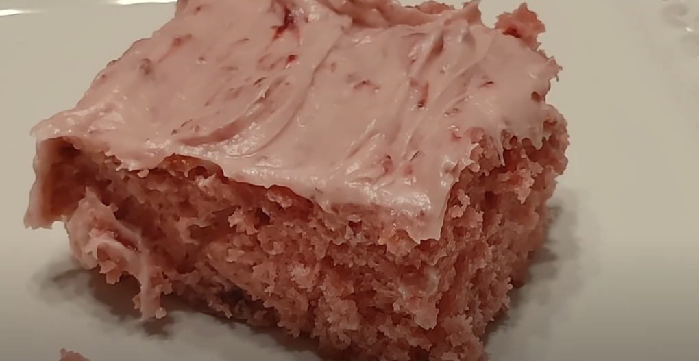 Slice of square pink Jello cake with pink frosting