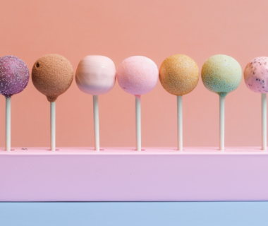 Assorted flavors of cake pops arranged in a pink stand